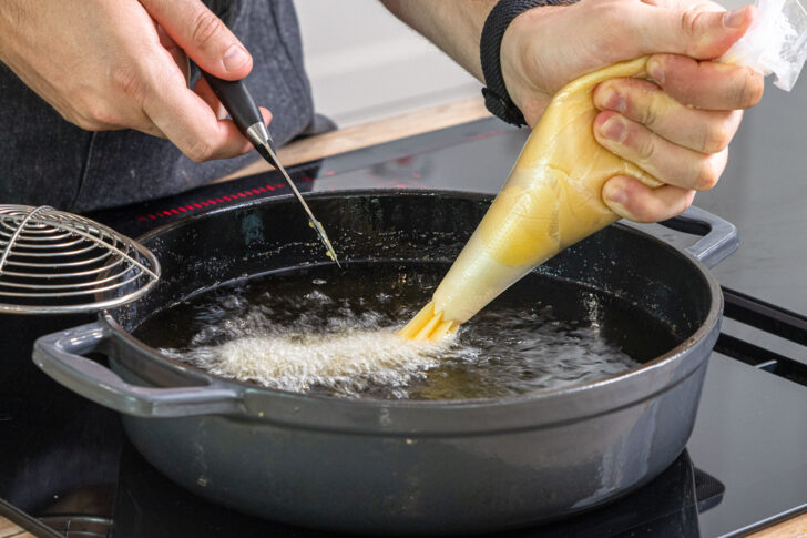 Churroteig in das Öl geben