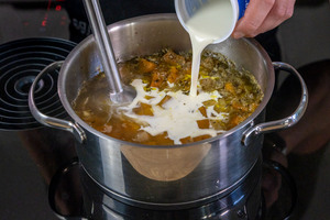 Sahne zur einfache und schnelle Kürbissuppe gießen