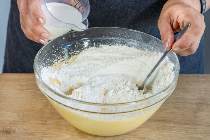 Milch mit in die Schüssel gießen