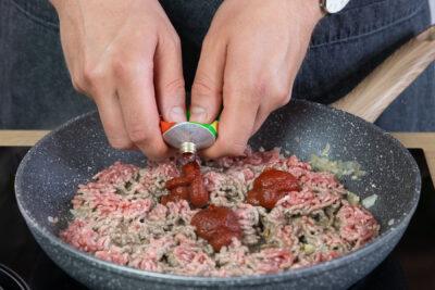 Tomatenmark zum Hackfleisch geben