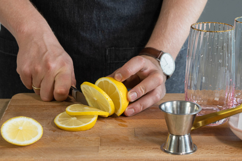 Zitrone für den Gin Tonic in Scheiben schneiden