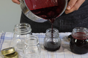 Holunderbeerengelee mit Apfelsaft in Gläser füllen