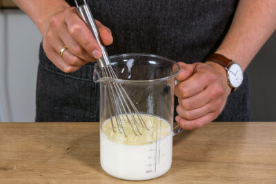 Milch und Öl in einem Messbecher vermischen