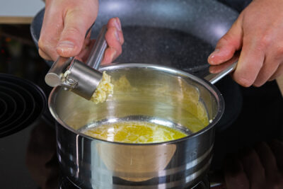 Knoblauch in einen Topf geben