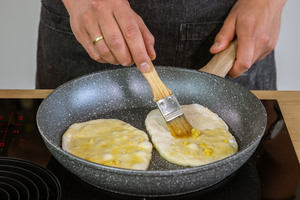 Naan mit Knoblauchbutter bepinseln