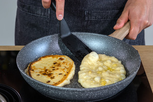 Knoblauch Naan in der Pfanne wenden