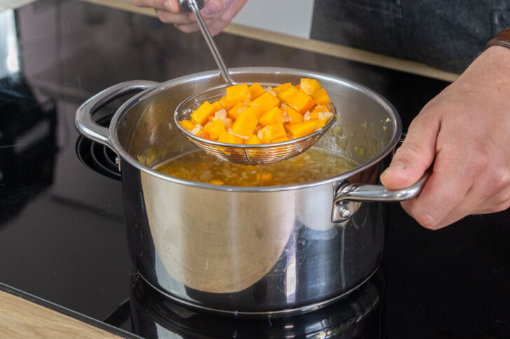 Kürbis aus Kürbissuppe mit Ingwer und Kokosmilch herausnehmen