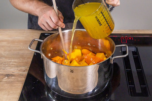 Gemüsebrühe zu dem Gemüse gießen