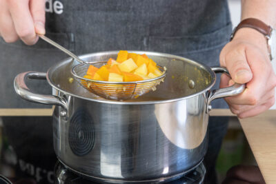 Gemüse für die Einlage der Kürbissuppe herausnehmen