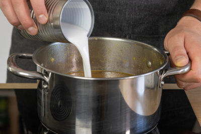 Kokosmilch dazugießen und die Kürbissuppe pürieren