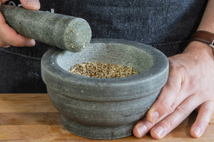 Gewürze mit Mörser zerstoßen