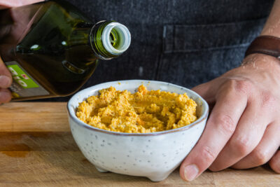 Öl auf Linsen-Hummus geben