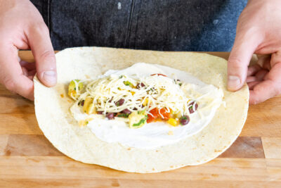 Füllung auf den mexikanischen Wrap geben