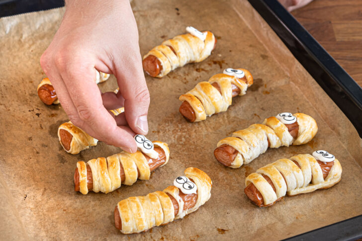 Mumien-Würstchen mit Zuckeraugen dekorieren