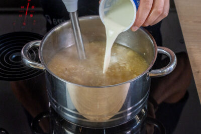 Sahne zu Omas cremiger Selleriesuppe gießen