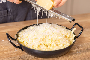 Parmesan über original Mac and Cheese reiben