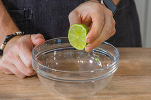 Limettensaft in eine Schüssel pressen