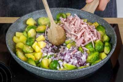 Knoblauch, Zwiebel und Schinken mit anbraten