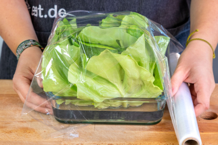 Salat in Wasserschale leicht mit Folie umwickeln