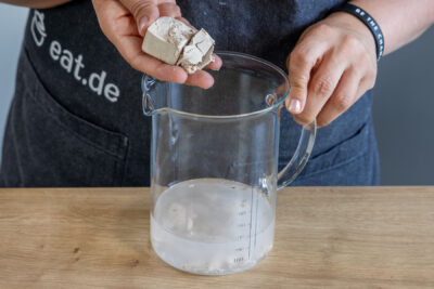 Hefe und Zucker in lauwarmen Wasser auflösen