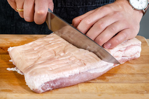 Schwarte des Schweinbauchs einschneiden