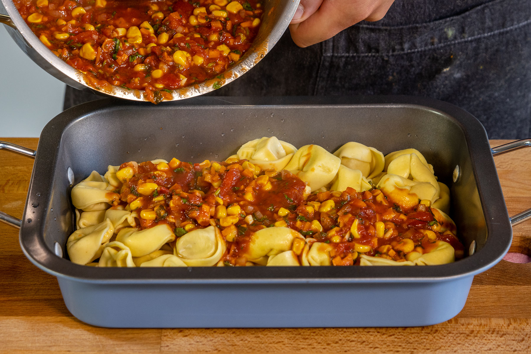 Tomatensauce auf die Tortellini geben