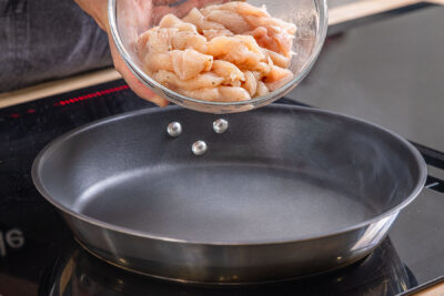 Hähnchenfleisch in die Pfanne geben