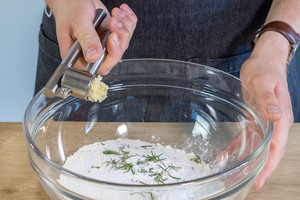 Knoblauch mit in die Schüssel pressen