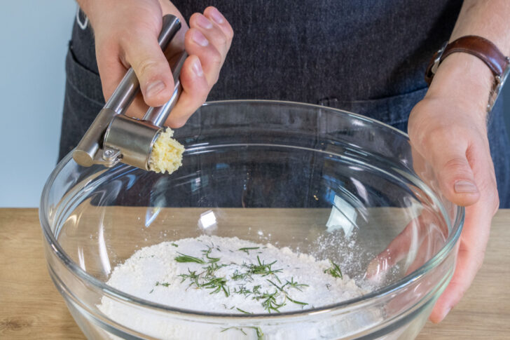 Knoblauch mit in die Schüssel pressen