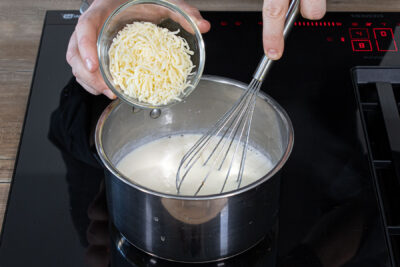 Käse unter die Béchamelsauce mischen
