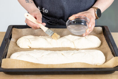 Baguettes mit Wasser bestreichen