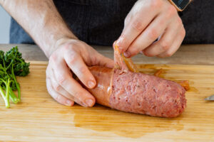 Haut von der Cotechino ziehen