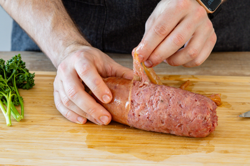 Haut von der Cotechino ziehen