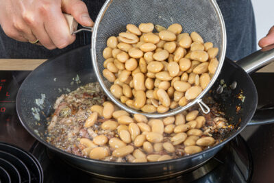 Weiße Riesenbohnen in die Pfanne geben