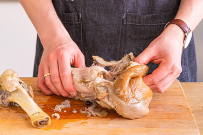Knochen und Schwarte vom Fleisch lösen