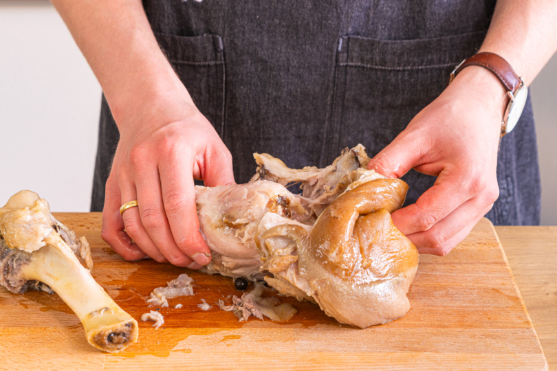Knochen und Schwarte vom Fleisch lösen