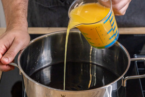 Orangensaft zu dem Wein gießen
