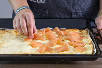 Räucherlachs auf dem Flammkuchen verteilen