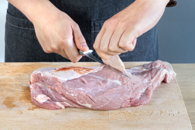 Sehnen und Fett vom Fleisch schneiden