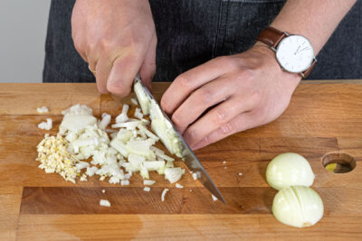 Zwiebeln und Knoblauch in Würfel schneiden