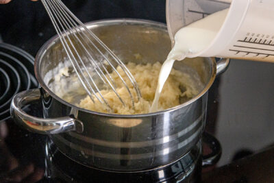 Milch in den Topf gießen