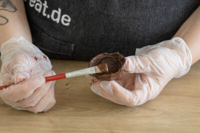 Eine Hälfte mit Schokolade bestreichen