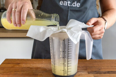 Ingwerbier durch ein Passiertuch gießen
