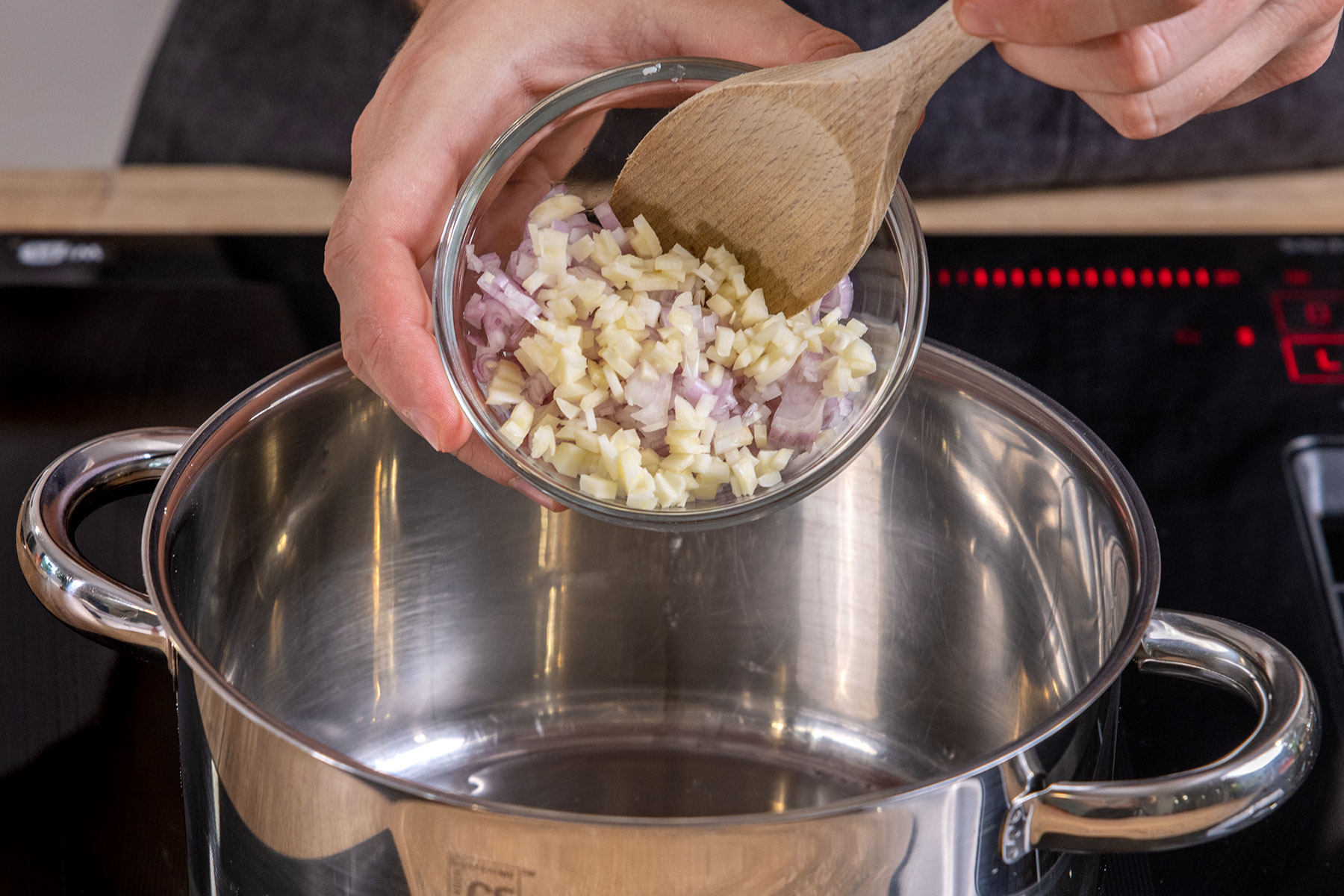 gewürfelte Zwiebel und Knoblauch in den Topf geben