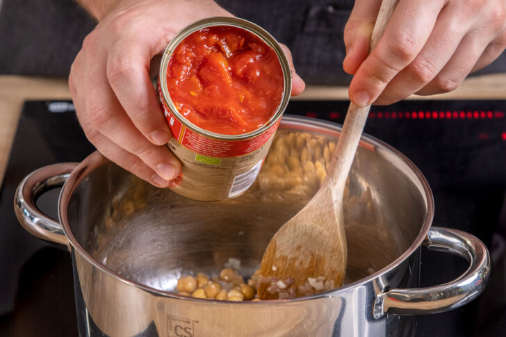 gehackte Tomaten zu den Kichererbsen in den Topf geben für Kichererbsen-Curry