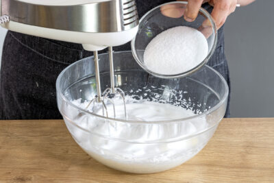 Zucker in Eischnee einrieseln lassen