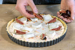 Feigen und Ziegenkäse auf der Kürbisquiche verteilen