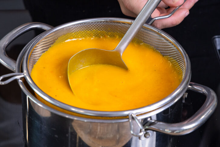 Kürbissuppe durch Sieb geben