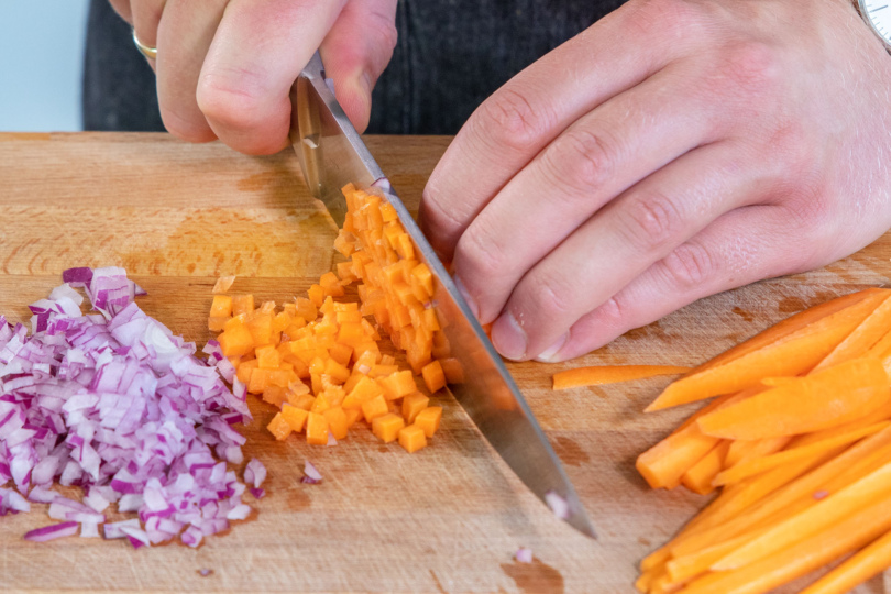 Zwiebel und Karotte in kleine Würfel schneiden