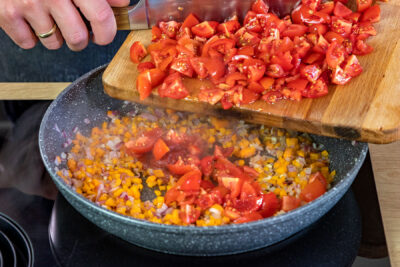 Tomatenmark und Tomatenstücke mit in die Pfanne geben